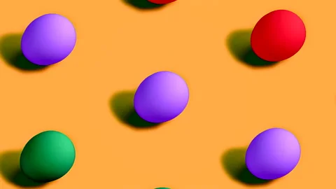 Colorful Easter Eggs rotating in rows in seamless loop on orange background. Stock Footage 150046323