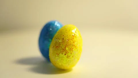 Colorful Easter eggs rotating in rows in a seamless loop on a light background Stock Photos