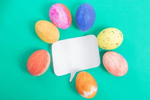 Colorful Easter eggs in a round shape with a blank speech bubble in green. Stock Photos