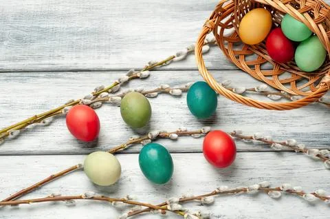 Colorful easter eggs on a rustic wooden surface with basket Stock Photos