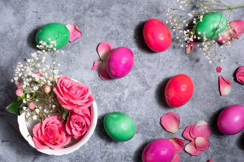 Colorful easter eggs scattered on gray concrete background, top view Stock Photos