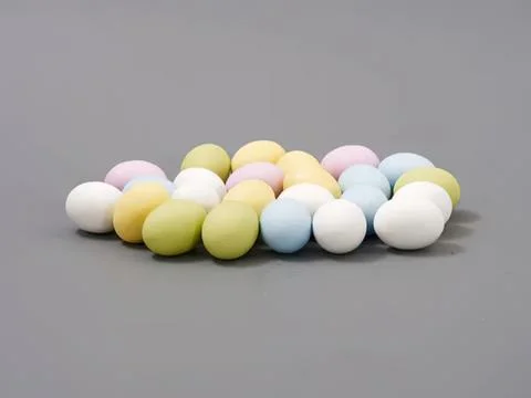 Colorful easter eggs scattered on gray surface Stock Photos