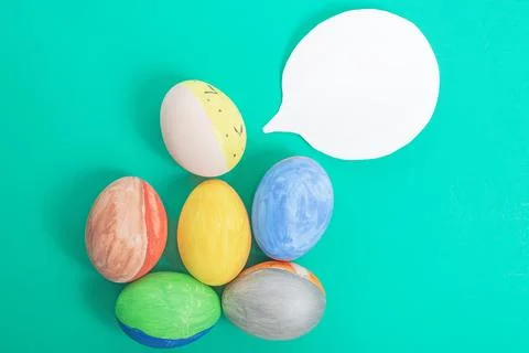 Colorful Easter eggs with speech bubble on green background. top view Stock Photos
