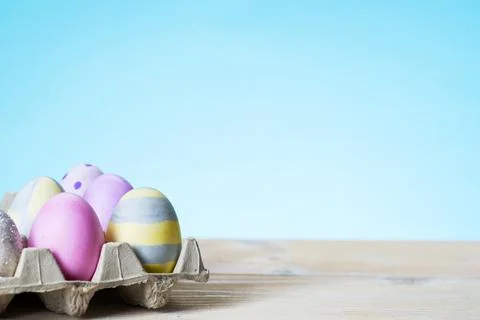 Colorful easter eggs on a stand on a table on a blue background Stock Photos