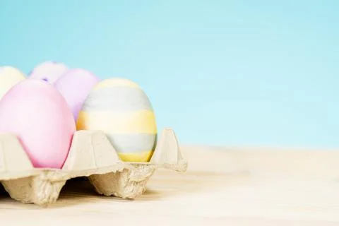 Colorful easter eggs on a stand on a table on a blue background Stock Photos