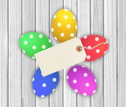 Colorful Easter Eggs with tag card over wooden background 库存照片