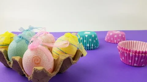 Colorful Easter eggs on a very peri background. nearby there are baking pans  Stock Photos