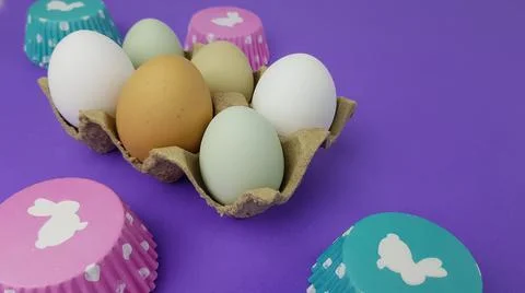 Colorful Easter eggs on a very peri background. nearby there are baking pans  Stock Photos