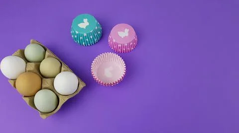 Colorful Easter eggs on a very peri background. nearby there are baking pans  Stock Photos