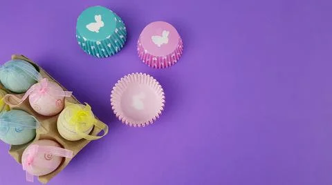 Colorful Easter eggs on a very peri background. nearby there are baking pans  Stock Photos