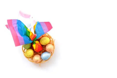 Colorful Easter eggs on a white background in a wicker basket in the style of Stock Photos