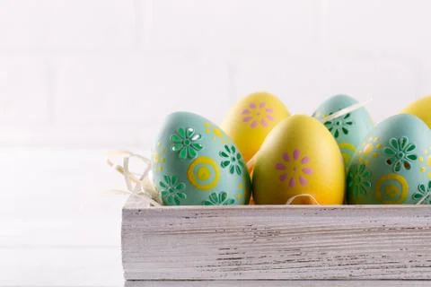 Colorful easter eggs in wooden box on white background. Easter holiday Stock Photos