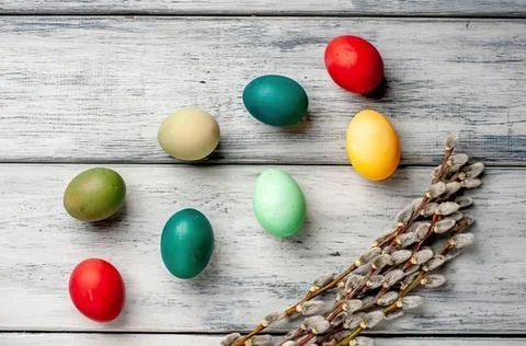 Colorful easter eggs on wooden surface with dried flowers Stock Photos