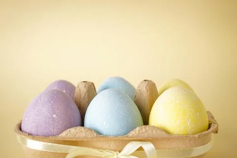 Colorful easter eggs on yellow background, close-up, place for text. Stock Photos
