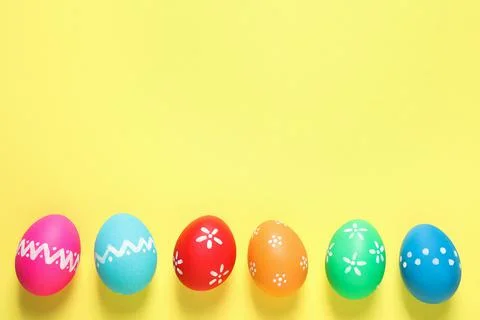 Colorful Easter eggs on yellow background, flat lay. Space for text 스톡 사진