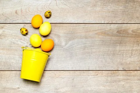 Colorful easter painted organic eggs lie in decor bucket on wooden rustic b.. 스톡 사진