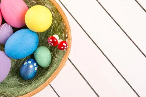 Colorful ecological styrofoam Easter eggs in basket on a wooden background Stock Photos