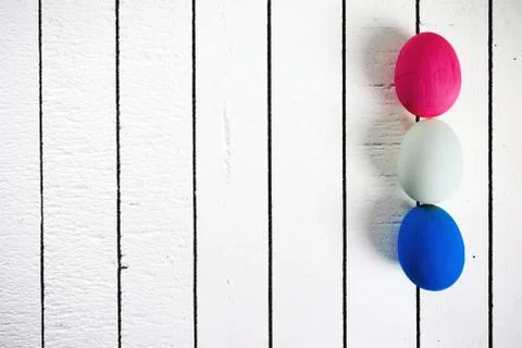 Colorful ecological styrofoam Easter eggs on a white wooden background. Frame Stock Photos