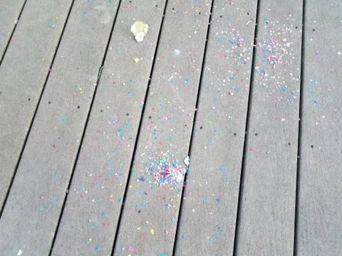 Colorful egg shells and paper confetti on wood deck Stock Photos