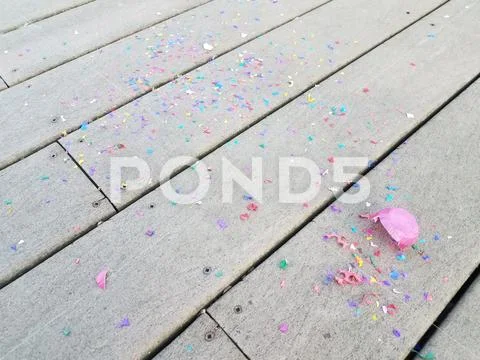 Colorful egg shells and paper confetti on wood deck Stock Photos