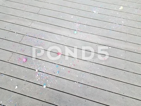 Colorful egg shells and paper confetti on wood deck Stock Photos