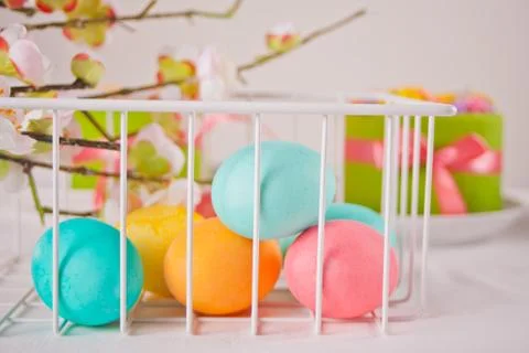 Colorful eggs for Easter day and small cakes on the background. 库存照片