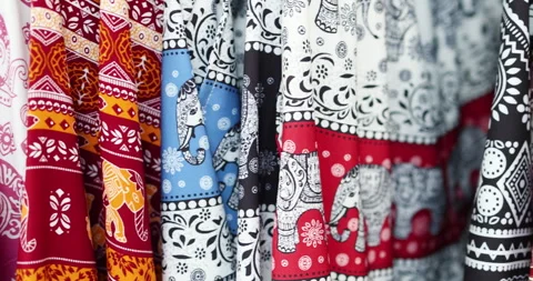 Colorful elephant patterned fabrics hanging in row, showcasing Asian textile Stock Footage 332477891
