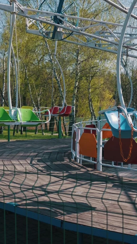 Colorful Empty Swings on Carousel Ride at Theme Park During Sunny Spring Day Stock Footage 334127328