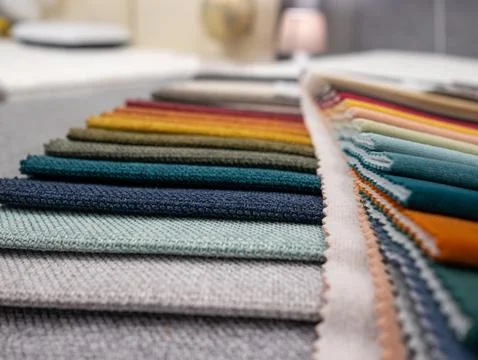 Colorful fabric samples on a table in a textile shop, close up Stock Photos