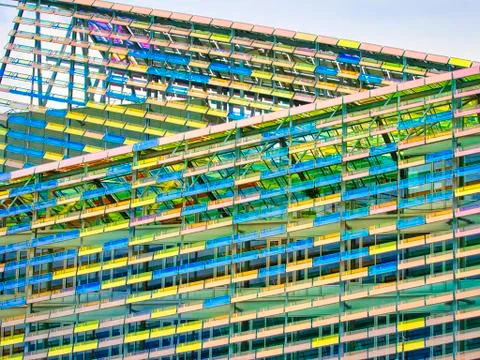 Colorful facade of a building with a vibrant rectangular window pattern. Glas Stock Photos