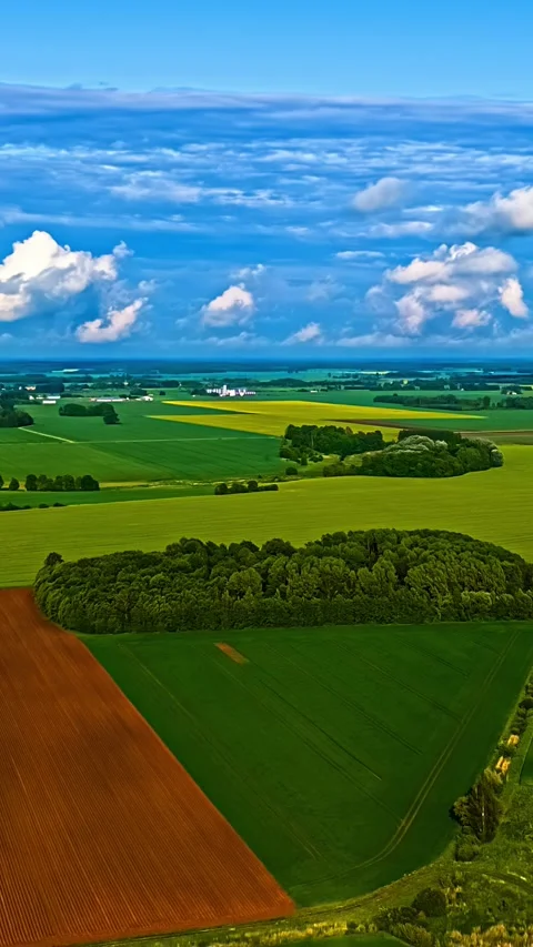 Colorful farmland patchwork under layered clouds Stock Footage 321050620