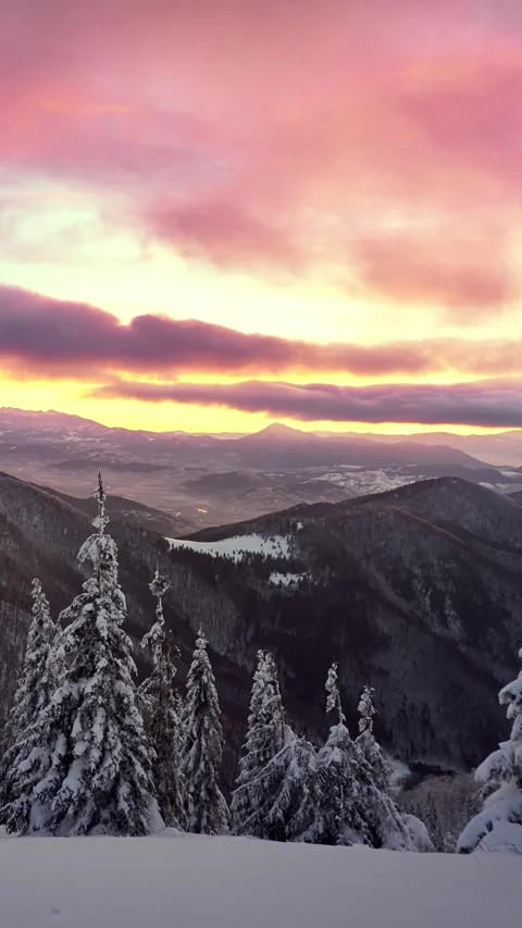 Colorful Fast Moving Clouds Over Frozen Winter Mountains and Snowy Forest at Видео 315979860
