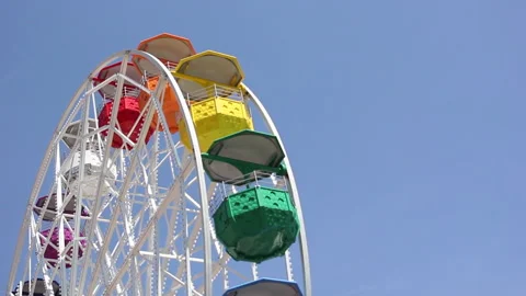 Colorful ferris wheel against blue sky Stock Footage
