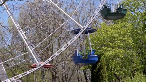 Colorful Ferris Wheel Gondolas Rotating Through Green Spring Trees Stock Footage 339074616