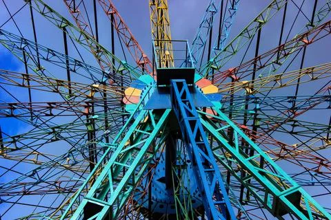 Colorful ferris wheel structure against blue sky Foto stock