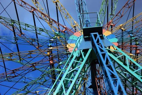 Colorful ferris wheel structure against blue sky Foto stock