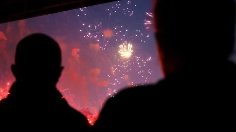 Colorful firework explodes beautifully close up in city sky front people 4K. Stock Footage 114348024
