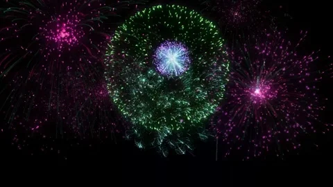 Colorful fireworks display exploding in nighttime sky with vibrant green and Stock-Footage 345863994