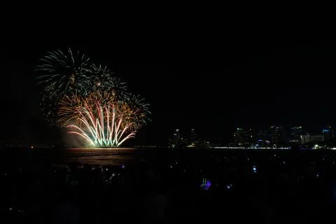 Colorful Fireworks Display Exploding Over The Ocean Night Skyline Wide Shot Stock Photos