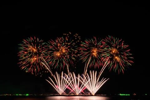 Colorful Fireworks Display Exploding Over Calm Sea Water At Night Long Expo.. 스톡 사진