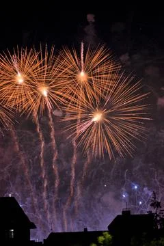 Colorful fireworks exploding over city buildings at night Stockfoto's