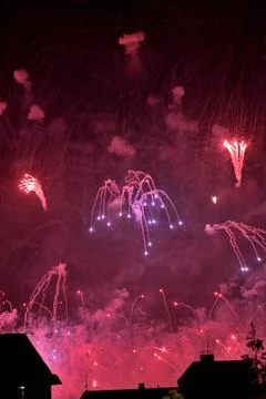 Colorful fireworks exploding over city buildings at night Stock Photos