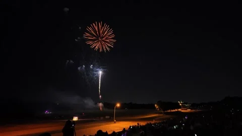 Colorful fireworks exploding over a crowd at night 動画素材 340938956