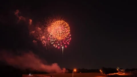 Colorful fireworks exploding over a crowd at night 库存影片 340941992