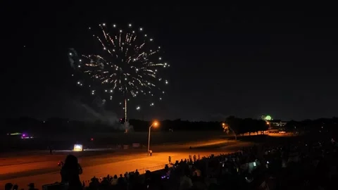 Colorful fireworks exploding over a crowd at night Stock Footage 340942162