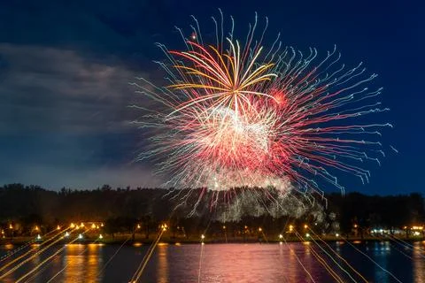 Colorful fireworks exploding over the river captured with long exposure in .. Stock Photos