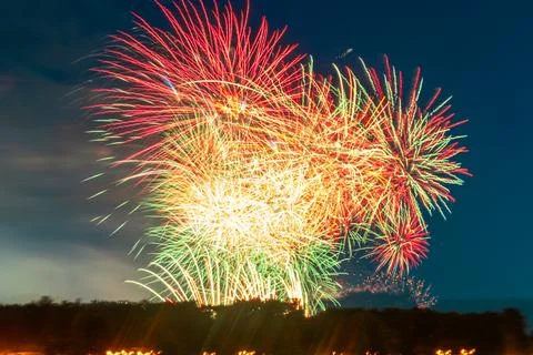 Colorful fireworks exploding over the river captured with long exposure in .. Stock Photos