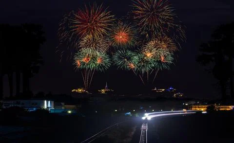 Colorful Fireworks Exploding Over Tropical Landscape With Railway Tracks Ho.. Foto stock