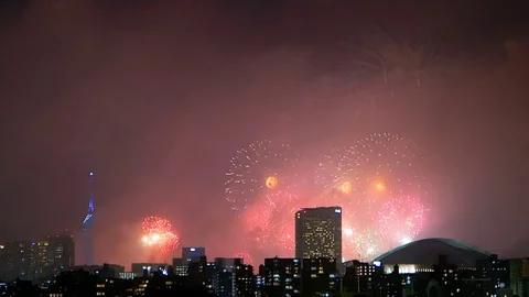 Colorful fireworks exploding in the sky of illuminated urban Fukuoka city. Stock Footage 78544305