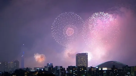 Colorful fireworks exploding in the sky of illuminated urban Fukuoka city. Stock Footage 78544493